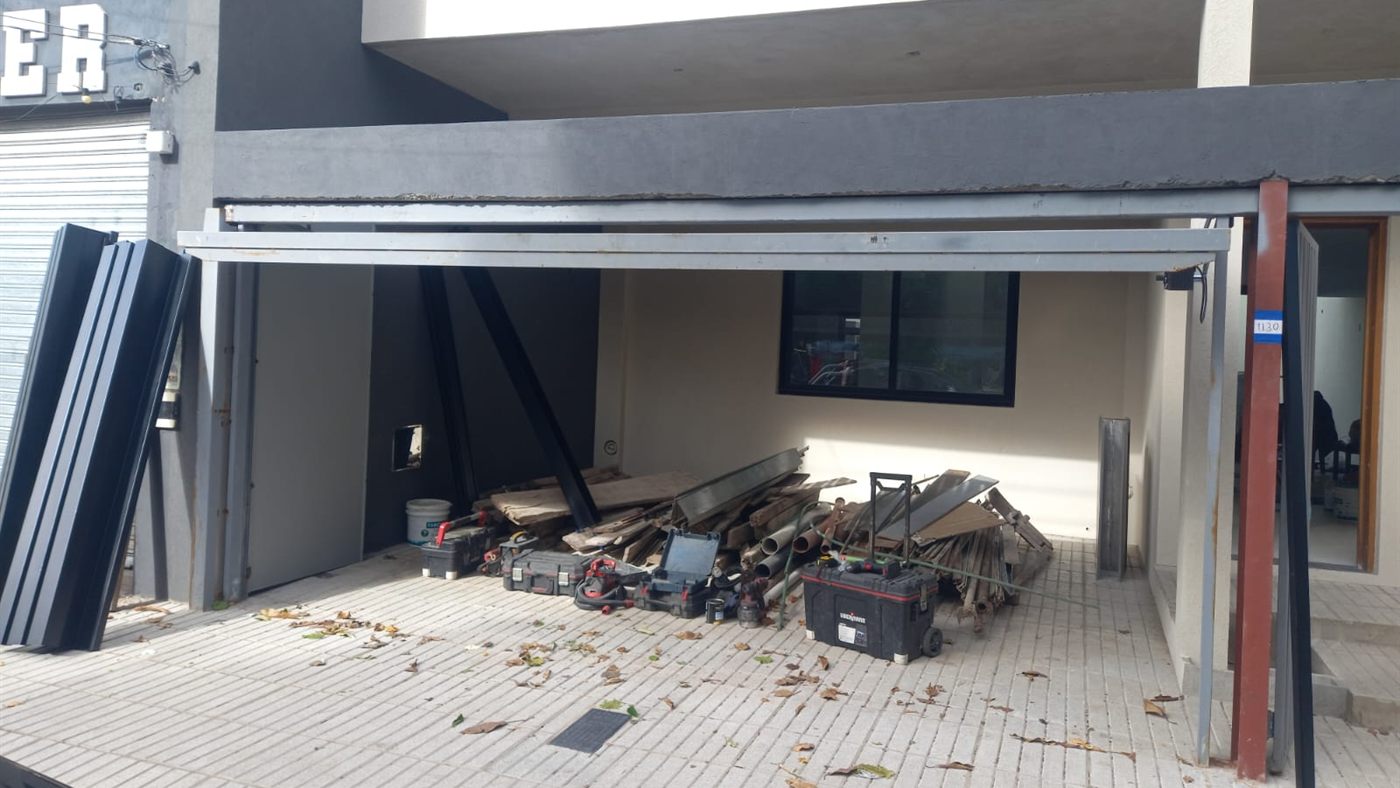Frente de la casa durante la obra, con la estructura metálica montada y la cochera todavía abierta